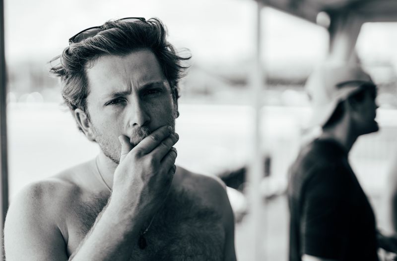 Hand over mouth, steady stare, black and white