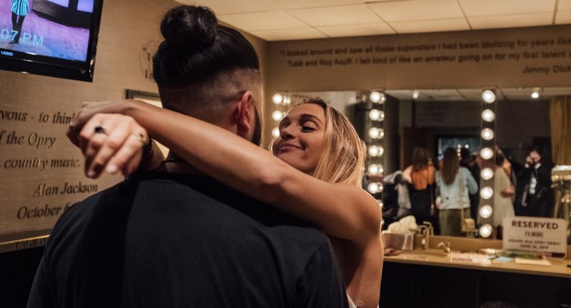 A hug in the dressing room, her smile, mirror lights behind