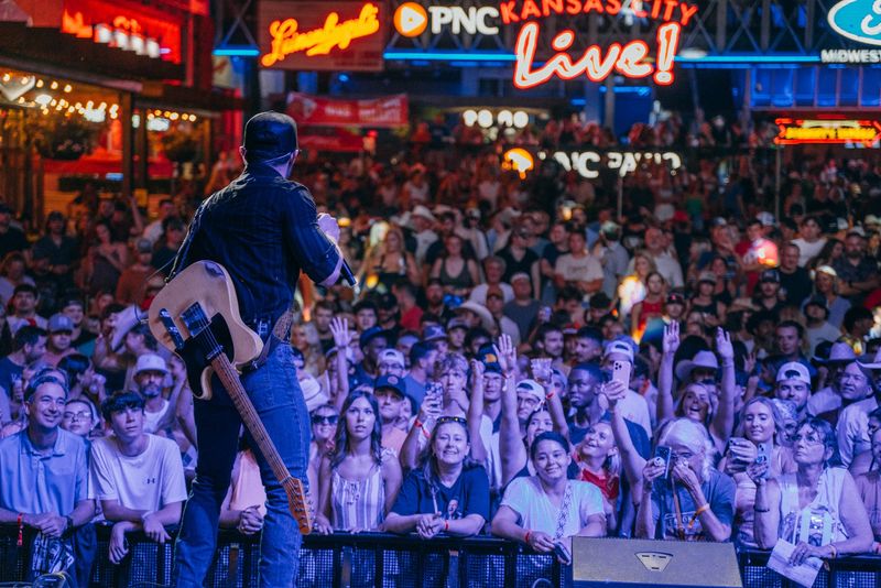 From behind the guitarist: huge crowd under Kansas City neon