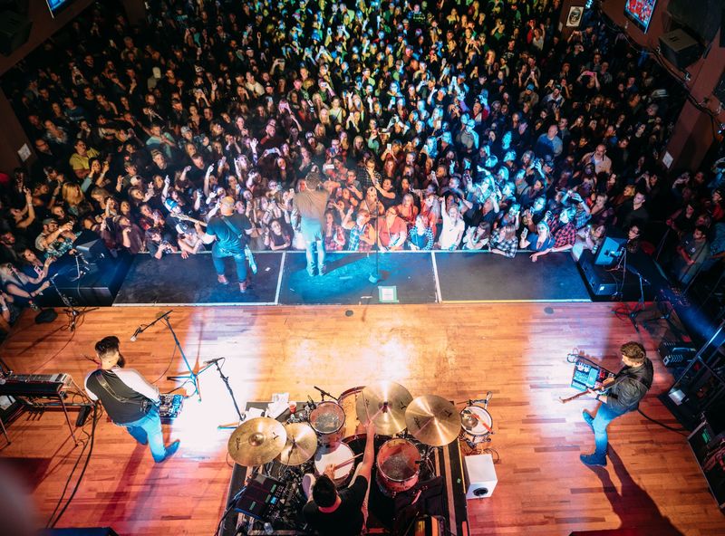 Overhead view of band and a packed, lit-up crowd