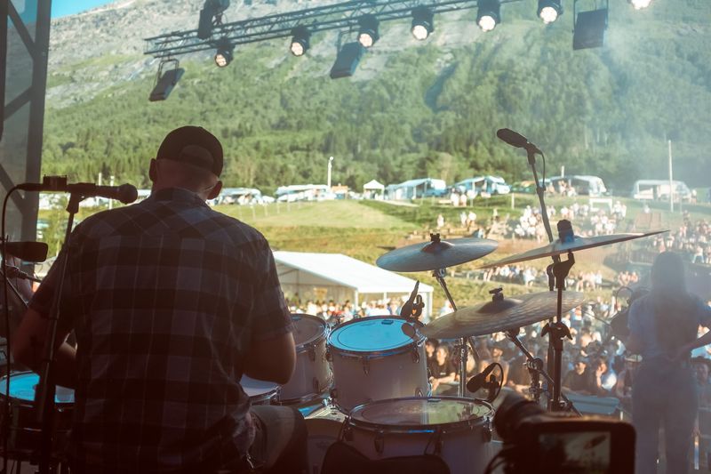 Behind the drummer, festival crowd under green Norwegian mountain