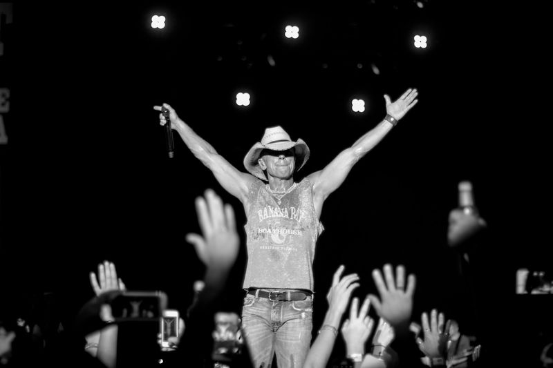 Arms flung wide over reaching hands, black and white